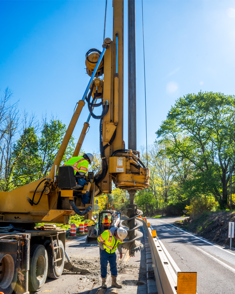 Inspecting the bit on C&J Well Co bucket rig drill