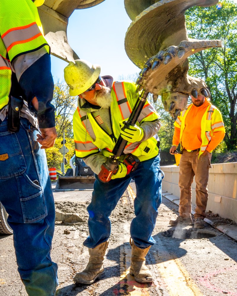 C&J Well Co staff replace teeth on bucket drill